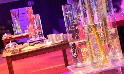 A trio of elevated cylindrical glass vases anchored each of the buffet tables.