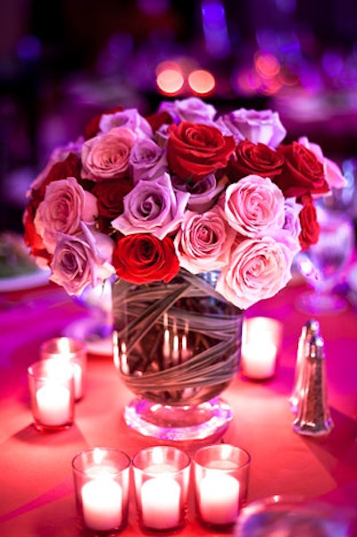 Some table centerpieces kept with the heart-centric theme, featuring red and pink roses by Winston Flowers and glass votives.