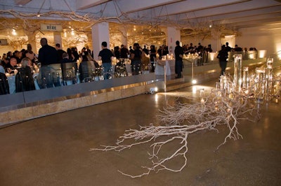 Giant branches and floating candles decorated a sunken area in the all-white dinner room, where 400 guests had vodka shots, caviar, burgers, and fries.
