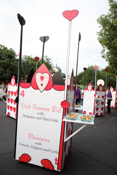 Oversize playing cards resembling the army from Alice in Wonderland served as food stations with descriptions of the foods on the cards.