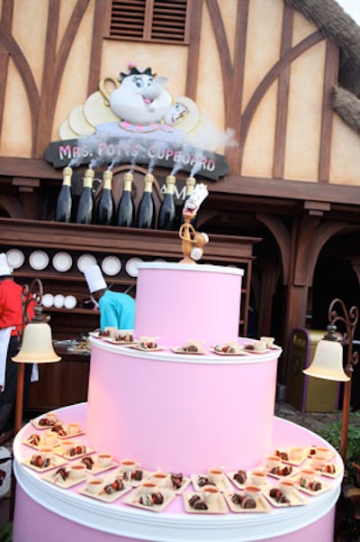 An oversize tiered 'cake' topped with Lumiere from Beauty and the Beast served as a food station in Fantasyland.