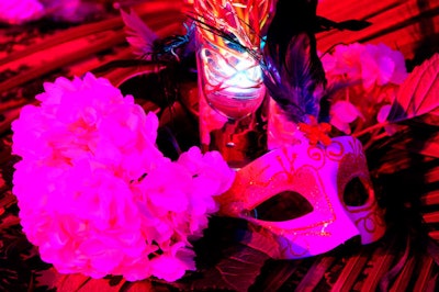 Elaborate masks decorated tables at the base of the centerpieces.
