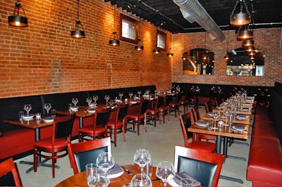 The 76-seat main dining room has exposed brick walls and arched openings for a view of the kitchen.