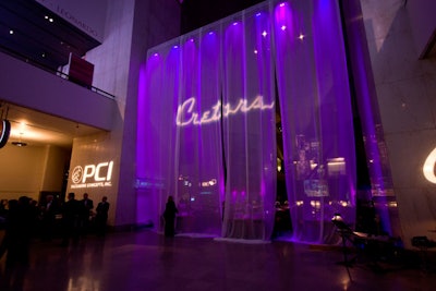A translucent curtain separated the cocktail reception from the dinner area. Sound Investment illuminated the divider with purple light and a company logo.