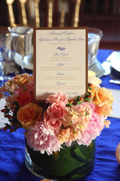 For the round dinner tables, Grand Floral Designs created tight centerpieces using several rose varieties, peonies, ranunculus, and orchids.