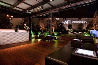A bright white gobo against an exterior wall announced A.F.I. and Deloitte.