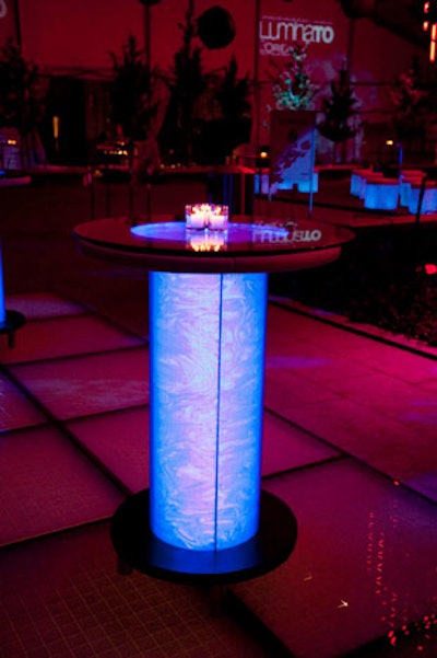 Illuminated cocktail tables and stools, two new products from Furnishings by Corey, cast a blue light throughout the tent.