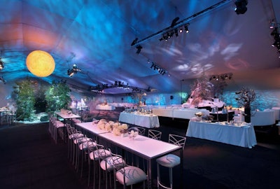 White chairs from Chameleon sat at long tables set with white flowers in the party tent.