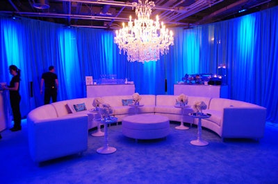 A white curved sectional sofa and ottoman from Contemporary Furniture Rentals provided seating in the backstage artist lounge, lit in blue in a nod to event sponsor Smarties.