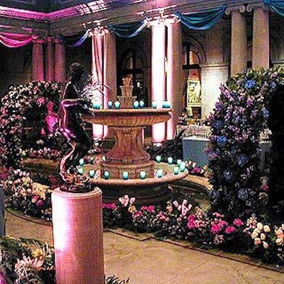 Spring and summer themes took over the garden court with fabric draped around the columns and floral arches wrapped with pink roses and blue and purple hydrangea, delphinium and lilies. The fountain was lined with blue votive candles.