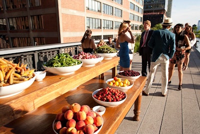 To feed guests during cocktails, Bite Food set up a long banquet table topped with bowls of seasonal fruits and vegetables from the green market. Without formal plates, guests picked fresh strawberries, plums, baby carrots, snap peas, and Easter egg and French breakfast radishes with their hands.