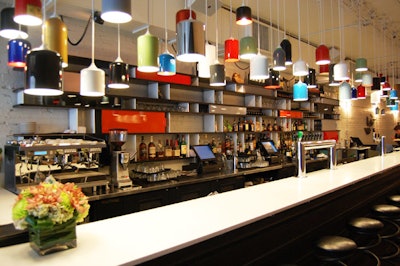 The 30-foot bar—constructed of c-channel steel beams—is illuminated by 85 lamps made from recycled fire extinguishers.