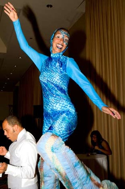 Stiltwalkers in blue costumes mingled with guests.