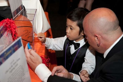 Chase Serrano, another local Wish Child, checked out silent auction items. Offerings included signed Chicago Bulls paraphernalia.