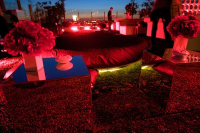 Oversize white leather sofas, which complemented the water beds in the rooftop space, provided comfortable areas for guests to lounge, while red peony bouquets and red projections reinforced the colors of the fragrance bottle.