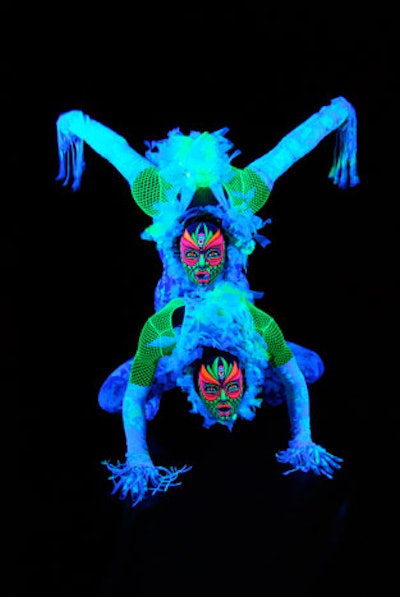 ArcheDream for Humankind dancers wear hand-painted masks and costumes lit by black lights.
