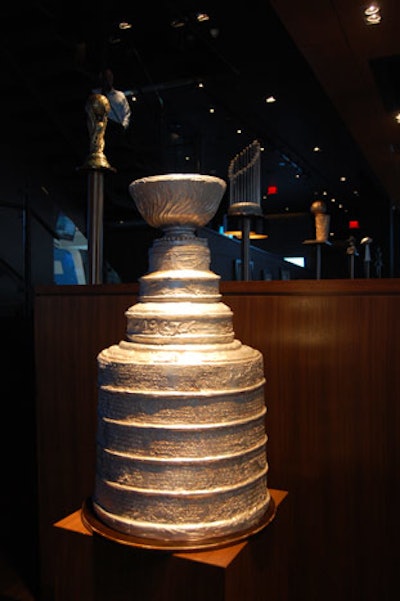 The decor includes replicas of major trophies like the Stanley Cup, the Vince Lombardi trophy, and the Heisman Trophy.