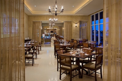 Shor American Seafood Grill is decorated with a neutral palette and sheer curtains dividing the dining areas.