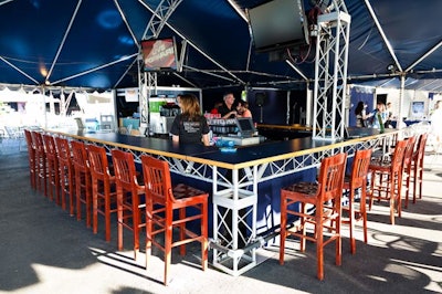 A wooden bar anchored the open-air party tent.