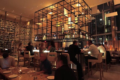 The bar area is adorned with suspended and floor-to-ceiling wine racks.