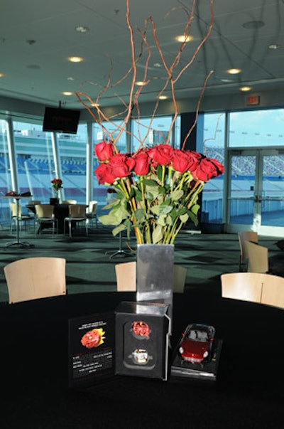 Arrangements of red roses topped black-clothed tables.