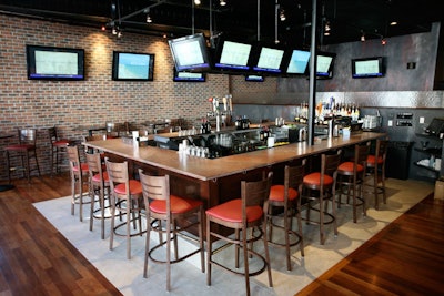 A rectangular TV-laden bar anchors the space.