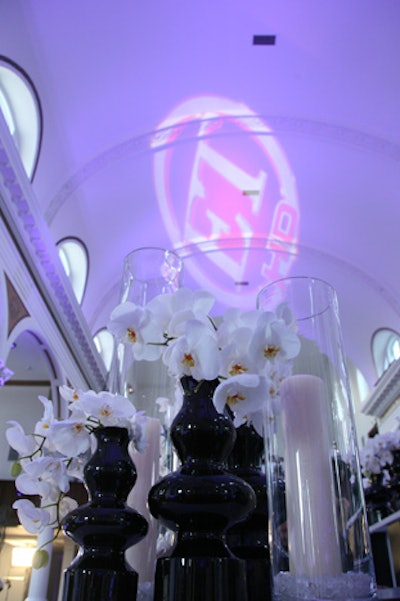 White orchids filled black vessels and a logo gobo decked the ceiling.