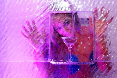 Dancers dressed as water creatures posed inside the two ice boxes as a stiltwalker poured drinks through the luges.