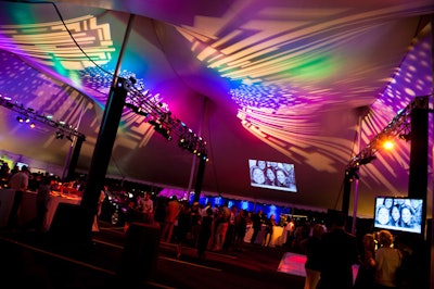 Warm lighting and projected photos of guests illuminated the tent interior.