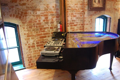 A DJ booth housed in a baby grand piano is tucked into the corner of the main room.