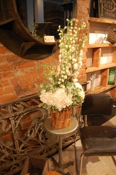 Jackie O Flowers supplied white arrangements in wood vases that were placed on furniture throughout the space.