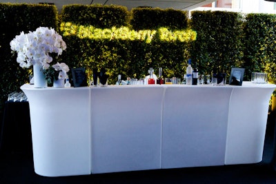 A BlackBerry gobo decked hedges behind a bar.
