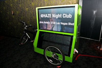 The Green Machine, a bike that hauls two flat screens, flashed promotional images as it sat in one of Haze's hallways.