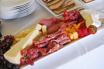 A buffet table included a selection of cheese and fruit platters.