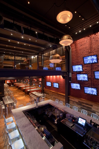 The first level, known as courtside, boasts a large U-shaped bar and 31 TVs and can accommodate 200 people for a private event.