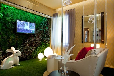 Francesca Bucci and Hans Galutera of BG Studio International designed the 'Clarity Lounge' for The Big C with a living wall, synthetic grass flooring, a swinging sofa suspended from the ceiling by Lucite chains, and an oversize lacquer rabbit sculpture.