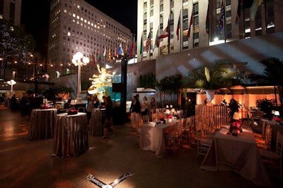 At Rockefeller Center's Rink Bar, vintage streetlamps, highboys covered in sequined linens, and white vases brimming with enormous arrangements of leafy ferns, feathers, and red roses, set the scene for guests coming from New York's premiere at Clearview's Ziegfeld theater.