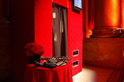 To allow the two photo booths to blend in with the ballroom's overall decor scheme, Stroud dressed the structures with quilted red velvet and placed tables of kinky props beside them.