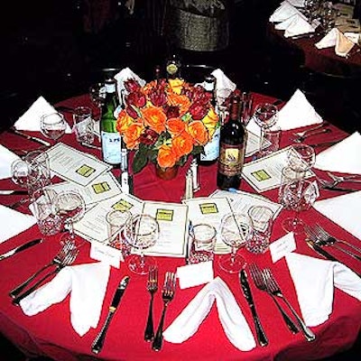 Rich red tablecloths and Musters & Company's centerpieces of red and orange flowers covered the round tables. The table numbers were put inside Coach picture frames with leather bases.
