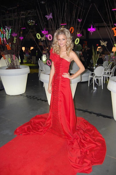 A model dressed in a flowing red gown greeted guests at the end of the red carpet.