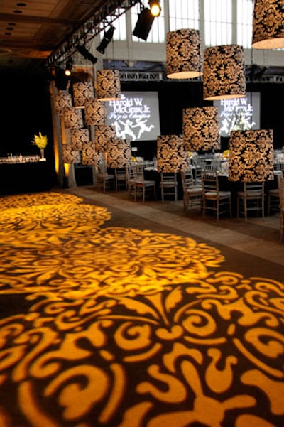 To separate the perimeter—where cocktails were held—from the dinner area, the team hung large lampshades from the ceiling. These pieces measured about two feet high and 22 inches in diameter, and their black and white embellishments were replicated in a pattern projected on the floors.