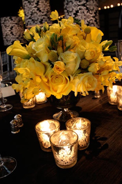 Short arrangements of yellow florals topped each of the dinner tables, matching the color of the lighting projections. The tables also held cards encouraging guests to tweet about the event using a specific hashtag.