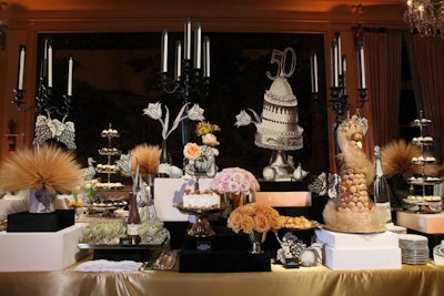 The dessert table had black-and-white trompe l'oeil-themed candelabras, flowers (including a variety of golden-hued live rose bouquets), and desserts.