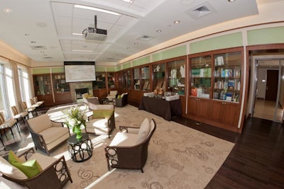 The library is decorated with a lighter palette of the university's signature green and orange in its paint and decorative pillows, and features a built-in projection and videoconferencing system.