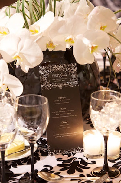 The tabletop settings complemented the decor overhead, with black-and-white cloths in various patterns covering the tables, black vases, white floral arrangements, and black-and-white napkin holders.