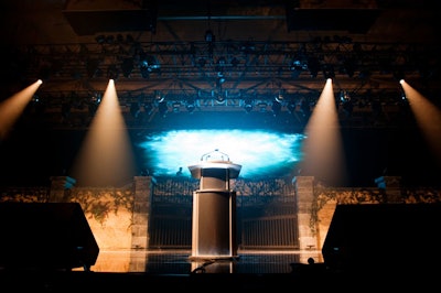 The backdrop for the massive stage include a garden wall and iron gate.