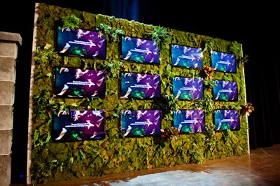 Green foliage surrounded 12 televisions (from presenting sponsor Samsung) on two media walls positioned on either side of the gate leading into the dining area.