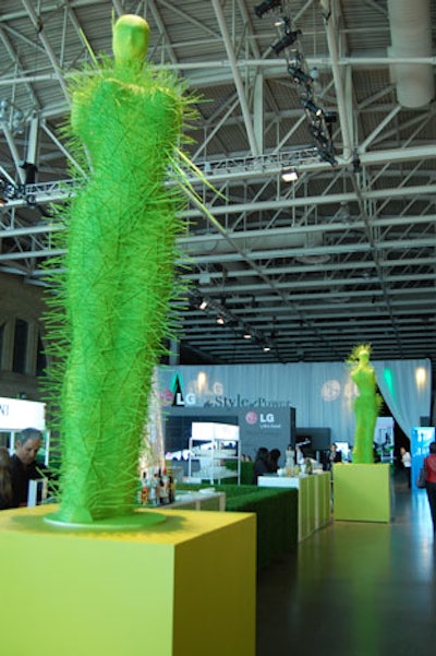 The sculptures, which resemble mannequins, are positioned on four chartreuse-coloured boxes surrounding the bar and fountain.