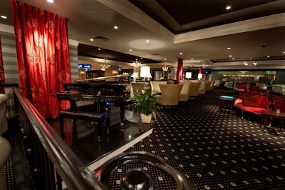A bilevel lounge is home to a piano and a marble bar.