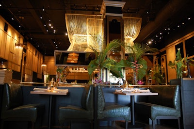 The main area of the Hurricane Club is the Hurricane Room, a large dining section decorated with butternut wood paneling, banquettes upholstered in forest green leather, and brass hurricane lamps.